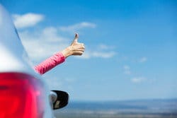 スペインで車を運転中に親指を立てる女性。