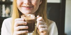 スペインの若い女性がコーヒーを持っています。