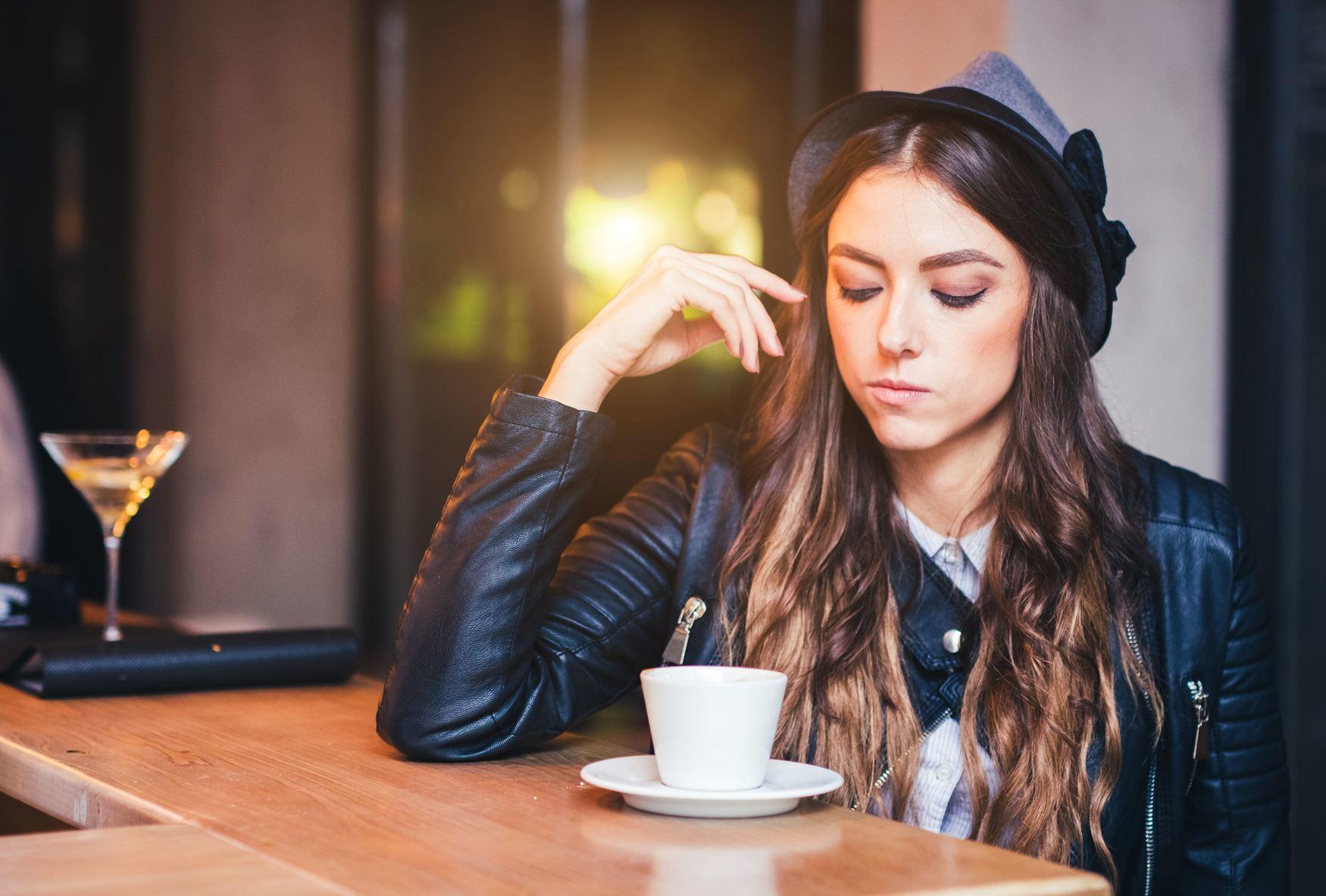 スペインでコーヒーを飲みながらテーブルに座る女性。
