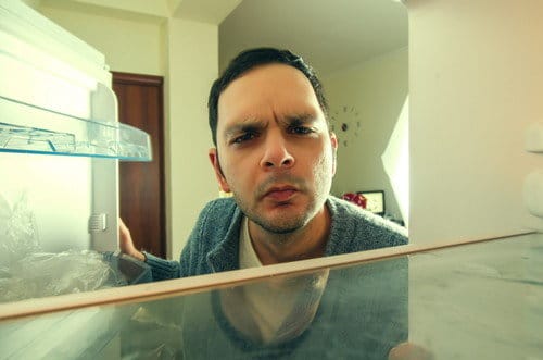 スペインの冷蔵庫の前に立つ男性。 スペインの冷蔵庫の前に立つ男性。