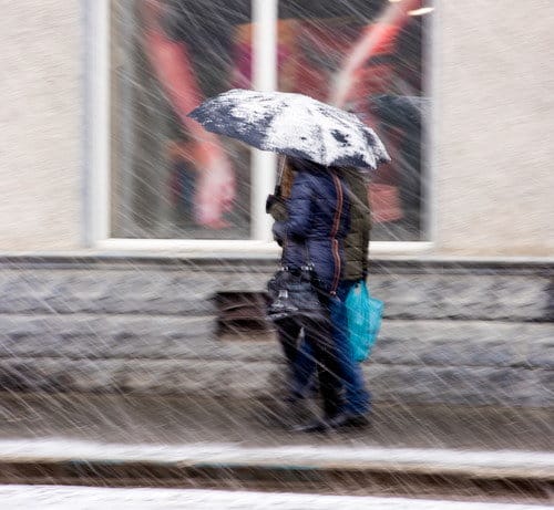 雪の中を傘をさして歩く二人、スペイン。