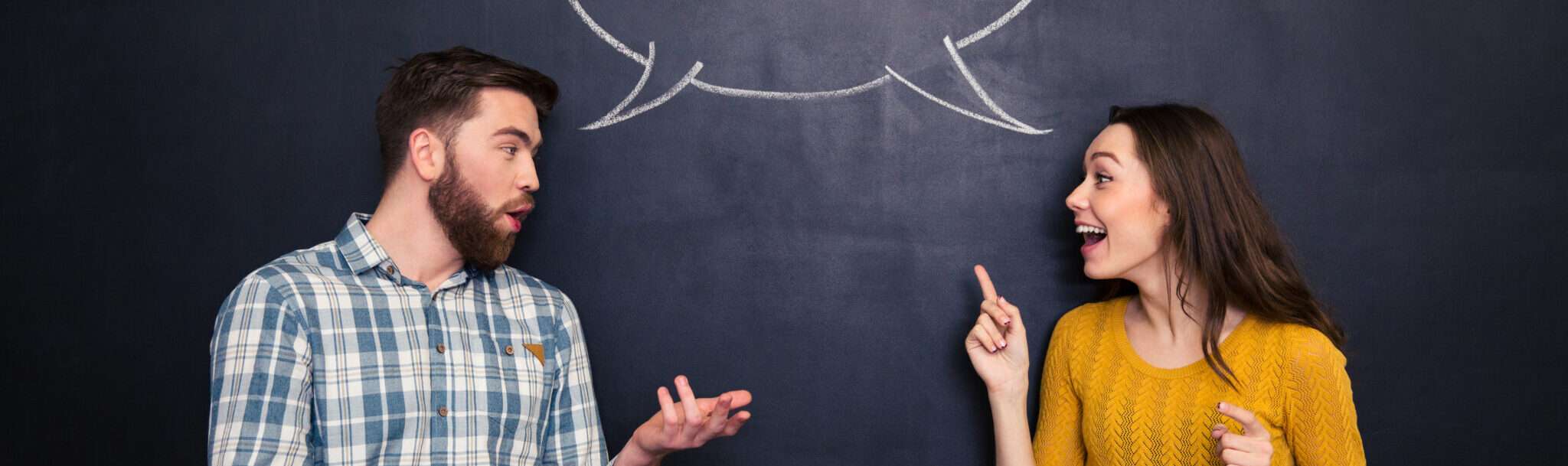 黒板の前でスペインについて話し合う 2 人。