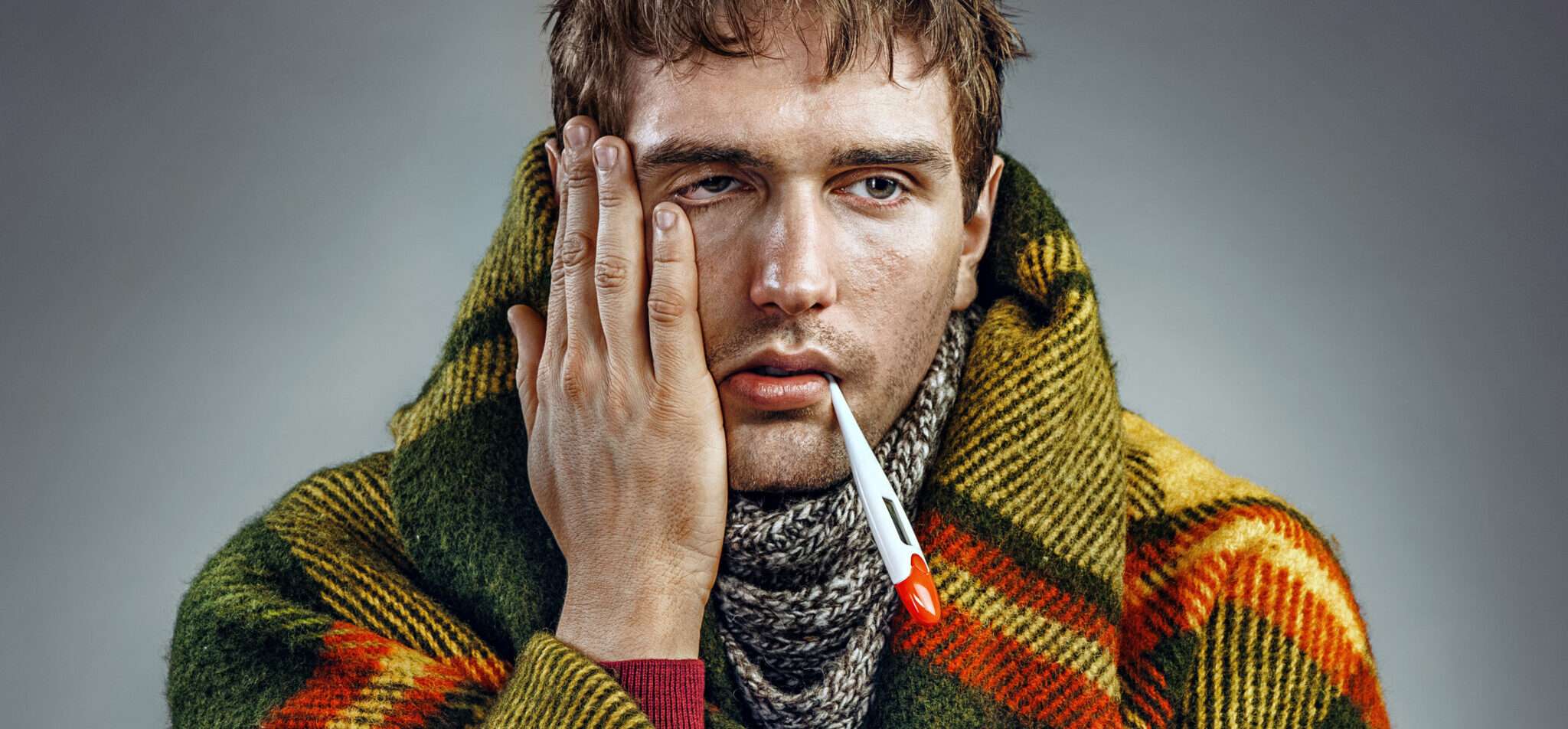 タバコを手に毛布にくるまったスペイン出身の男性。