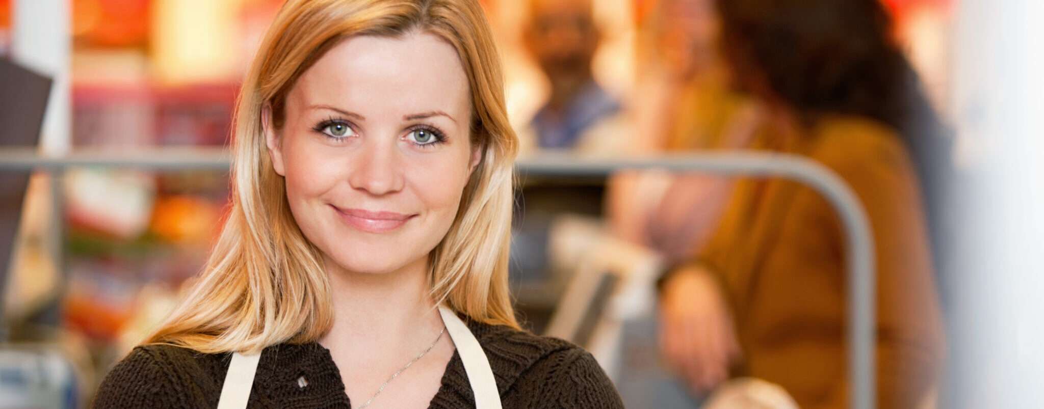 スペインの食料品店に立つエプロン姿の女性。