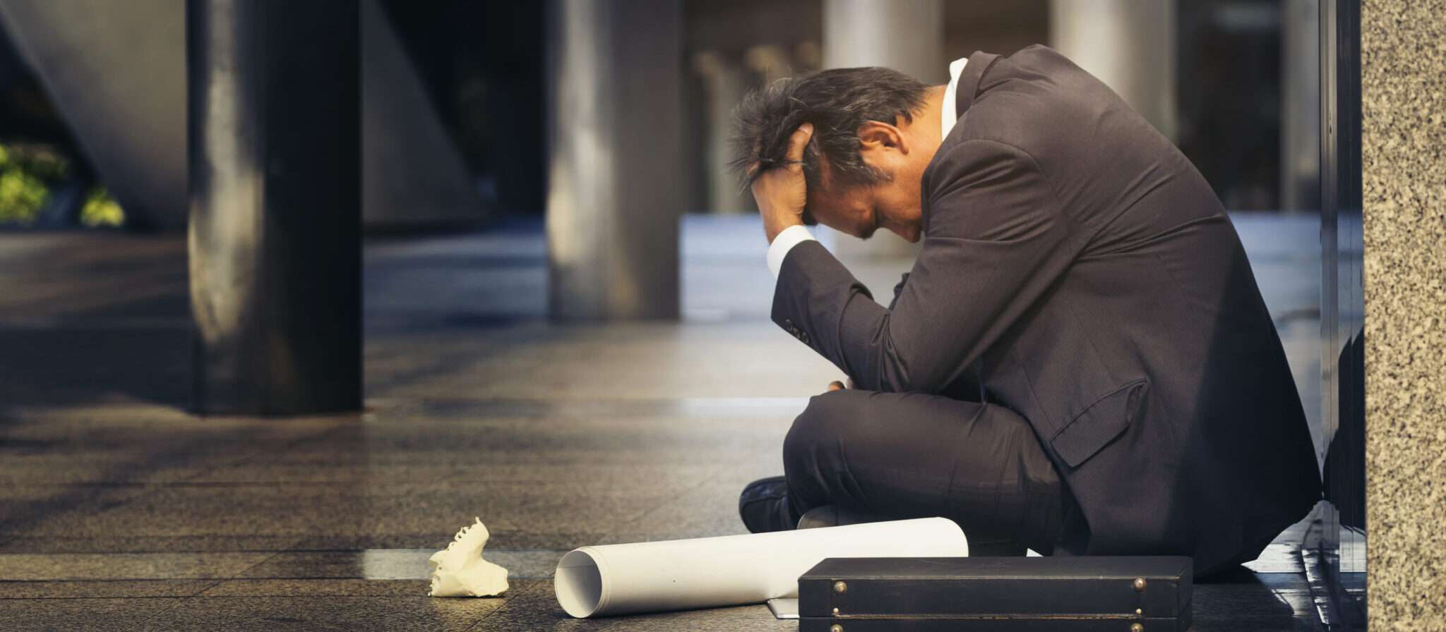 スペインで地面に座るスーツを着た男性。