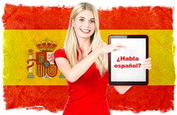 背景にスペインの国旗が描かれたタブレットを持っている女性。