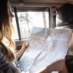 女性が車の後部座席に座ってスペイン (スペイン) の地図を見ています。