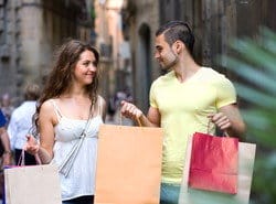 スペインの街路で買い物袋を持った若いカップル。