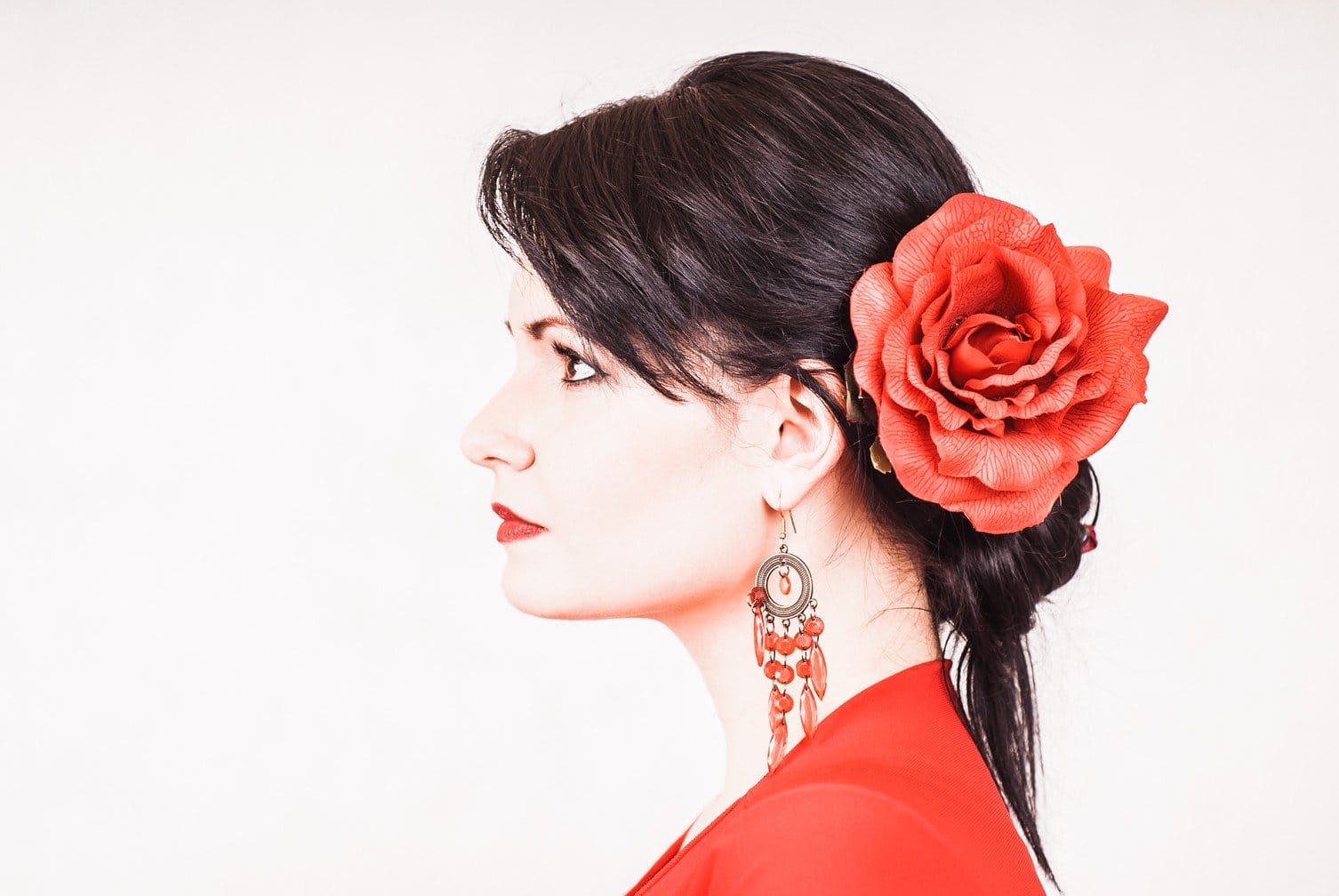 赤いドレスを着て、髪に花を咲かせたスペインの女性。