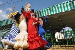 テントの前で踊るスペイン風のドレスを着た女性のグループ。