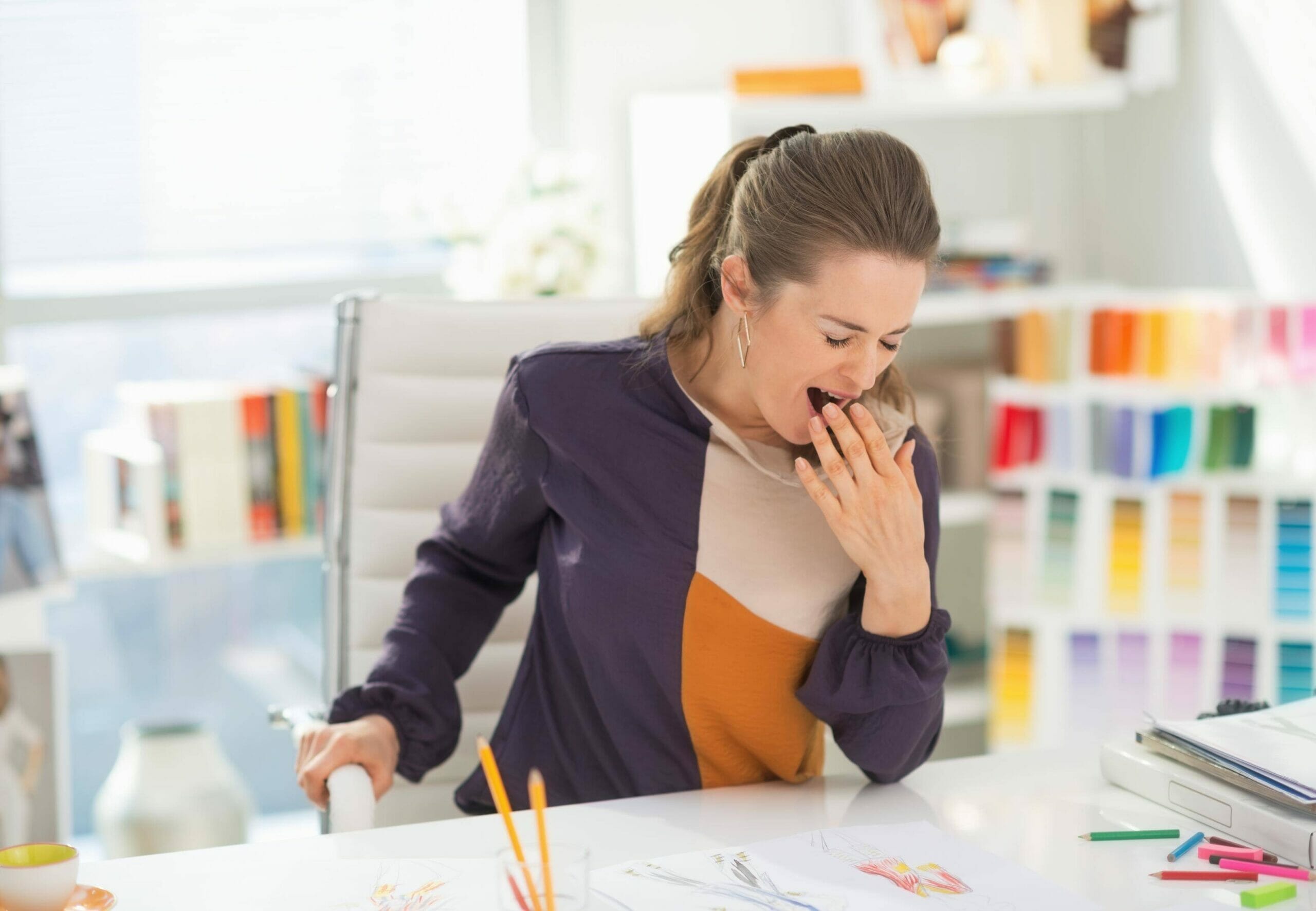 スペインで机に座ってくしゃみをしている女性。