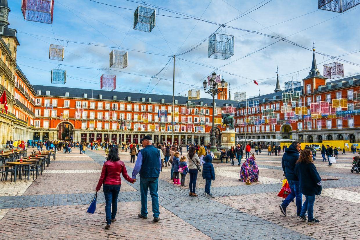 スペインのマドリードの広場で人々が歩いています。