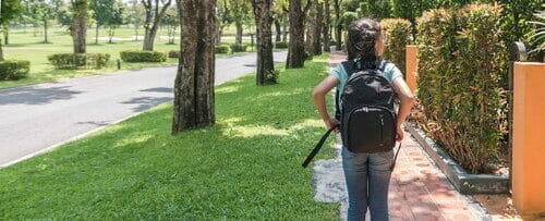 スペインの歩道をバックパックを背負って歩く若い女の子。