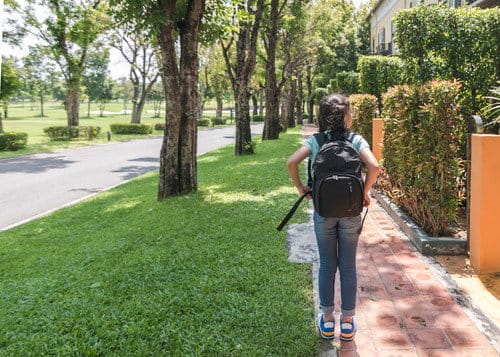 スペインの歩道をバックパックを背負って歩く若い女の子。