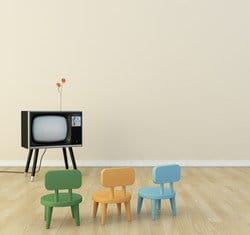 スペインのテレビの前にある 3 つのカラフルな椅子。