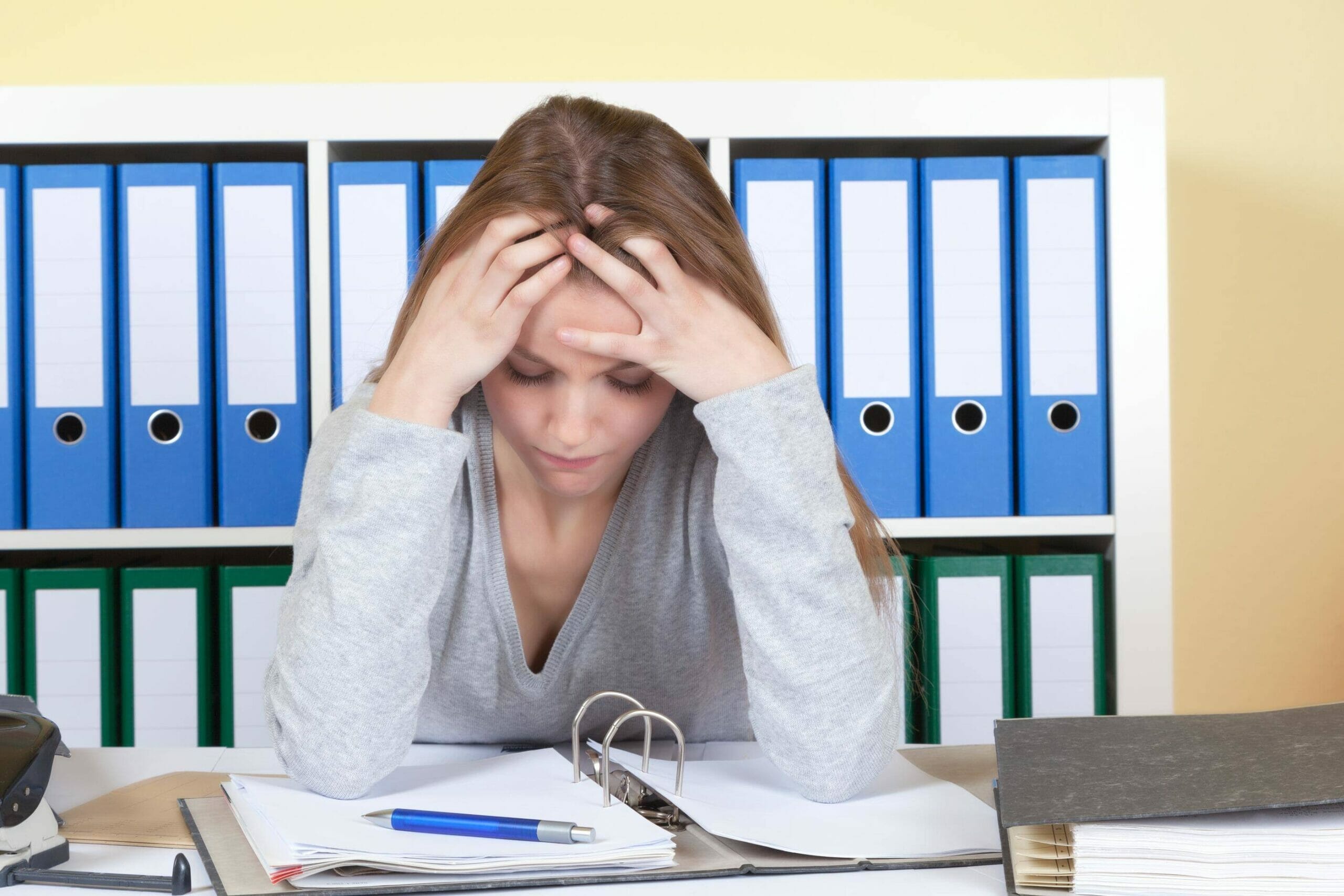 女性が机に座り、頭を抱えてスペインについて考えを巡らせている。