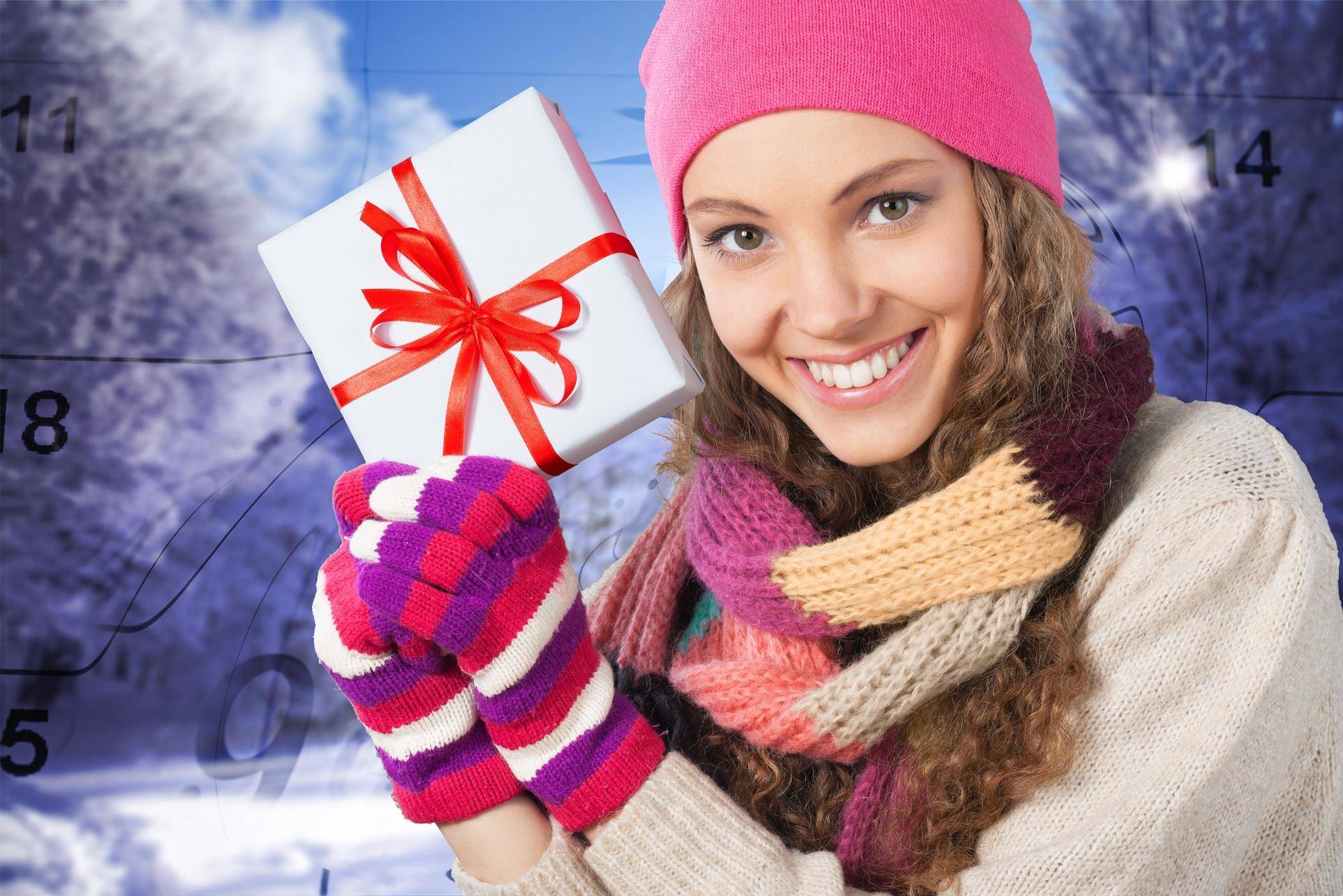 スペインの雪の背景の前でギフトボックスを持つ女性。 スペインの雪の背景の前でギフトボックスを持つ女性。