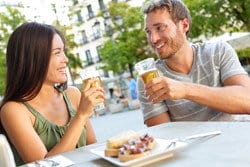 スペインの屋外テーブルでビールを飲んでいる男性と女性。