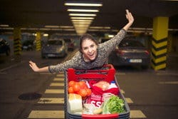 スペインの駐車場でショッピング カートに乗る女性。