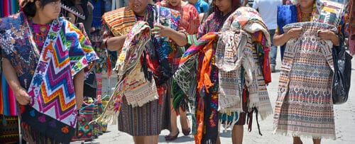 スペインをイメージしたカラフルな服を着た女性のグループが通りを歩いています。