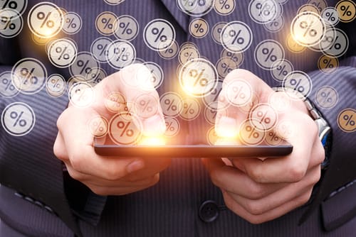 スペインのビジネスマンが、パーセント記号の付いたスマートフォンを持っています。