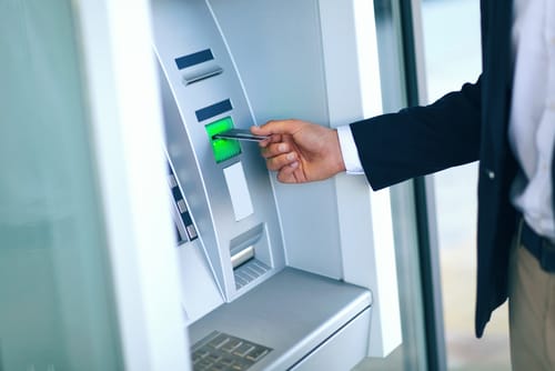 男性がスペインの ATM にお金を入れています。