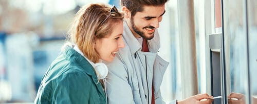 スペイン出身の男性と女性が ATM を見ています。