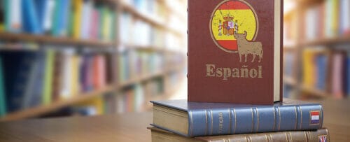 説明: 本のスペイン国旗が本棚の前のテーブルに置かれています。