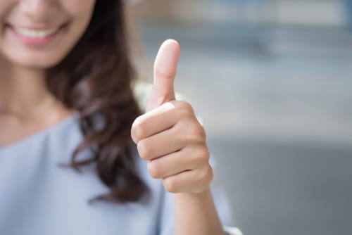 スペインの服装で親指を立ててサインをする女性。