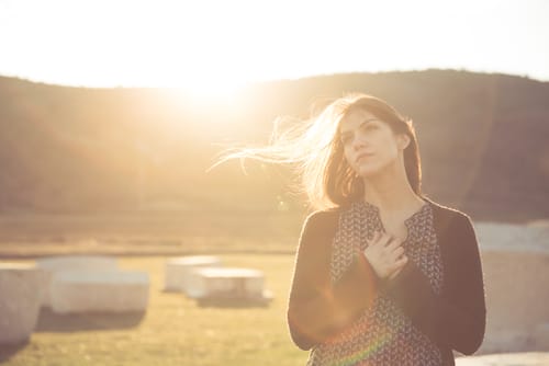 スペインで太陽を背に野原に立つ女性。