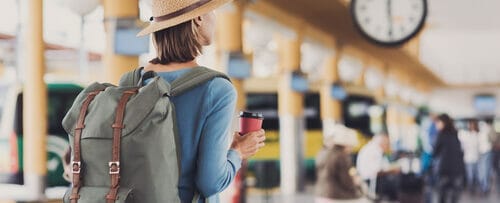 バックパックを背負ってスペインの駅に立つ女性。