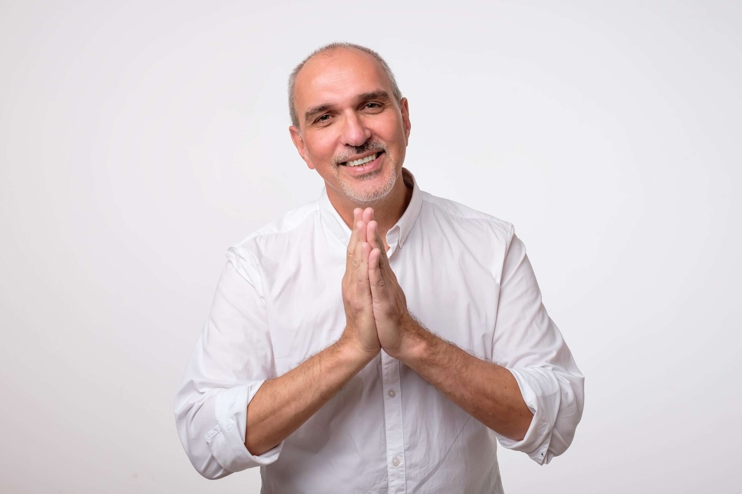 白い背景の前で手を組む男性、スペイン。