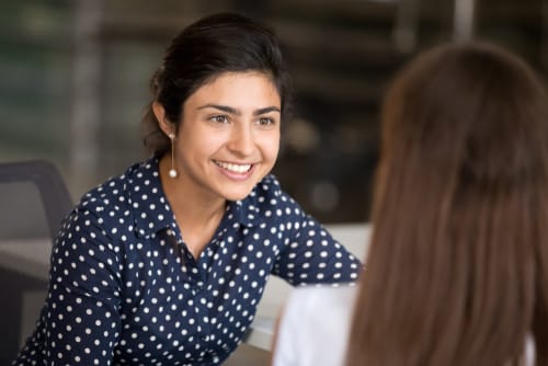 スペインのオフィスで女性が別の女性と話しています。