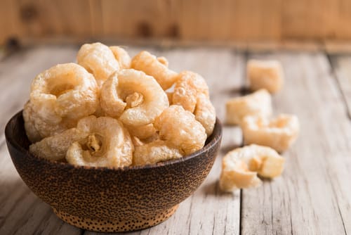 木のテーブルの上のボウルにスペイン風タコの揚げ物。
