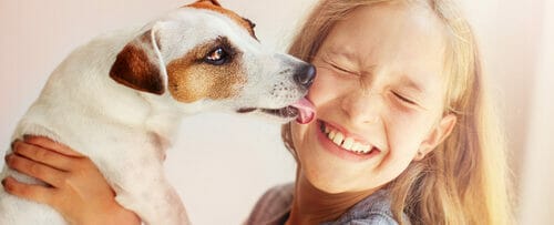 スペインの女の子が犬を抱いています。