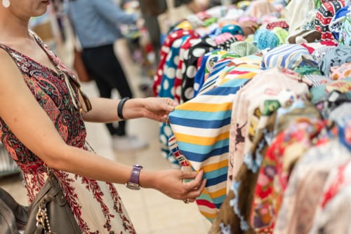 女性がスペインの店で服を見ています。