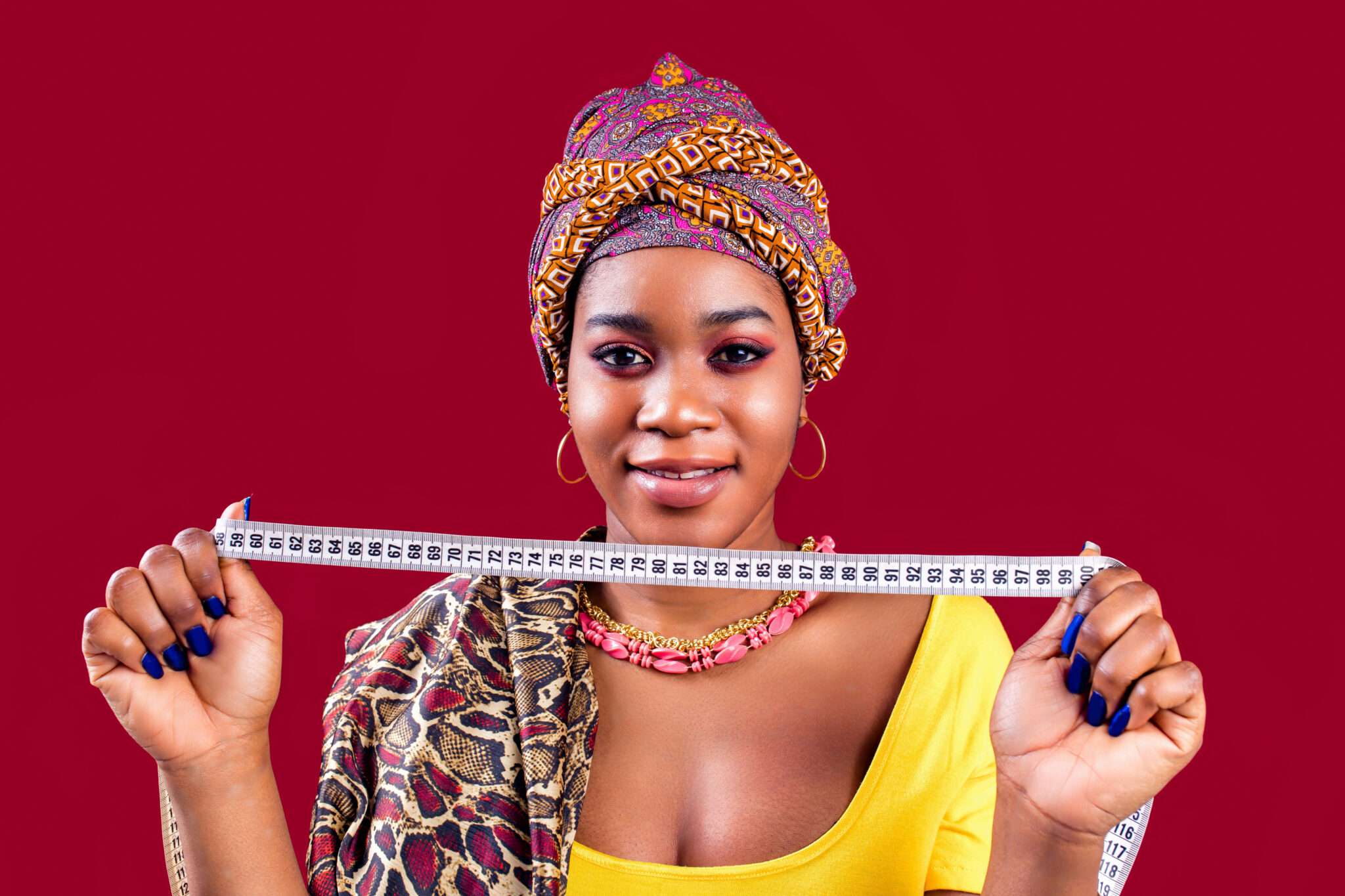 スペインの赤い背景に巻尺を掲げる女性