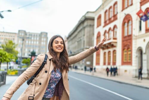 スペインの路上に腕を広げて立っている若い女性。