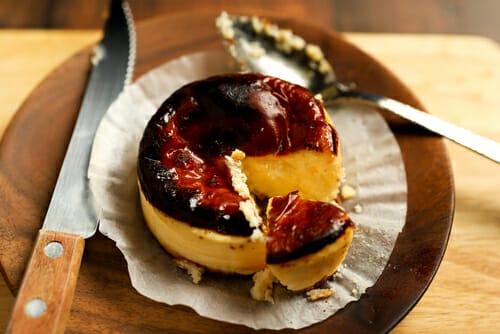 スペインのナイフで皿に置かれたチーズケーキのスライス。