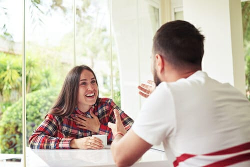 テーブルに座って話しているスペイン人の男女。