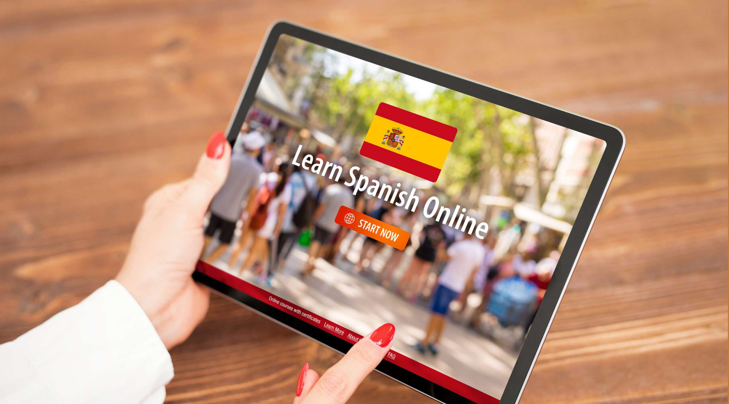 女性はスペイン語のウェブサイトが表示されたタブレットを持っています。