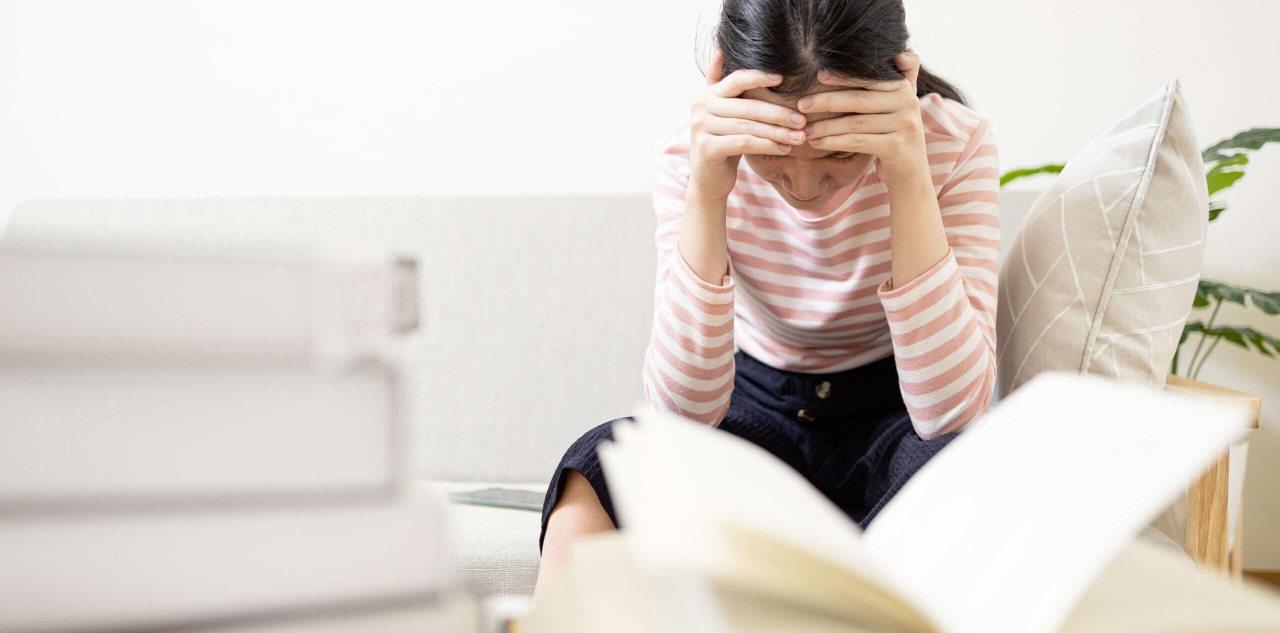 本を開いて一般的に使用されるスペイン語の動詞「quedar(se)」の意味と用法を勉強している女性。