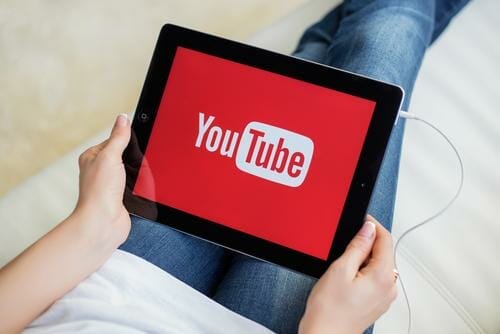 スペイン滞在中に YouTube のロゴが入ったタブレットを持っている女性。