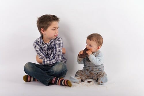 スペインで床に座ってケーキを食べる二人の少年。