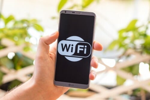 スペインの wifi ロゴが入ったスマートフォンをかざす人。