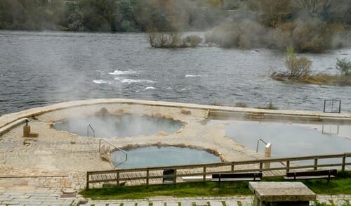 スペインの川のそばにある、蒸気が出る温水浴槽。