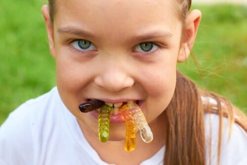 スペインの少女が口の中で虫を食べています。