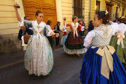 スペインの伝統的な衣装を着た女性のグループがスペインの路上で踊ります。