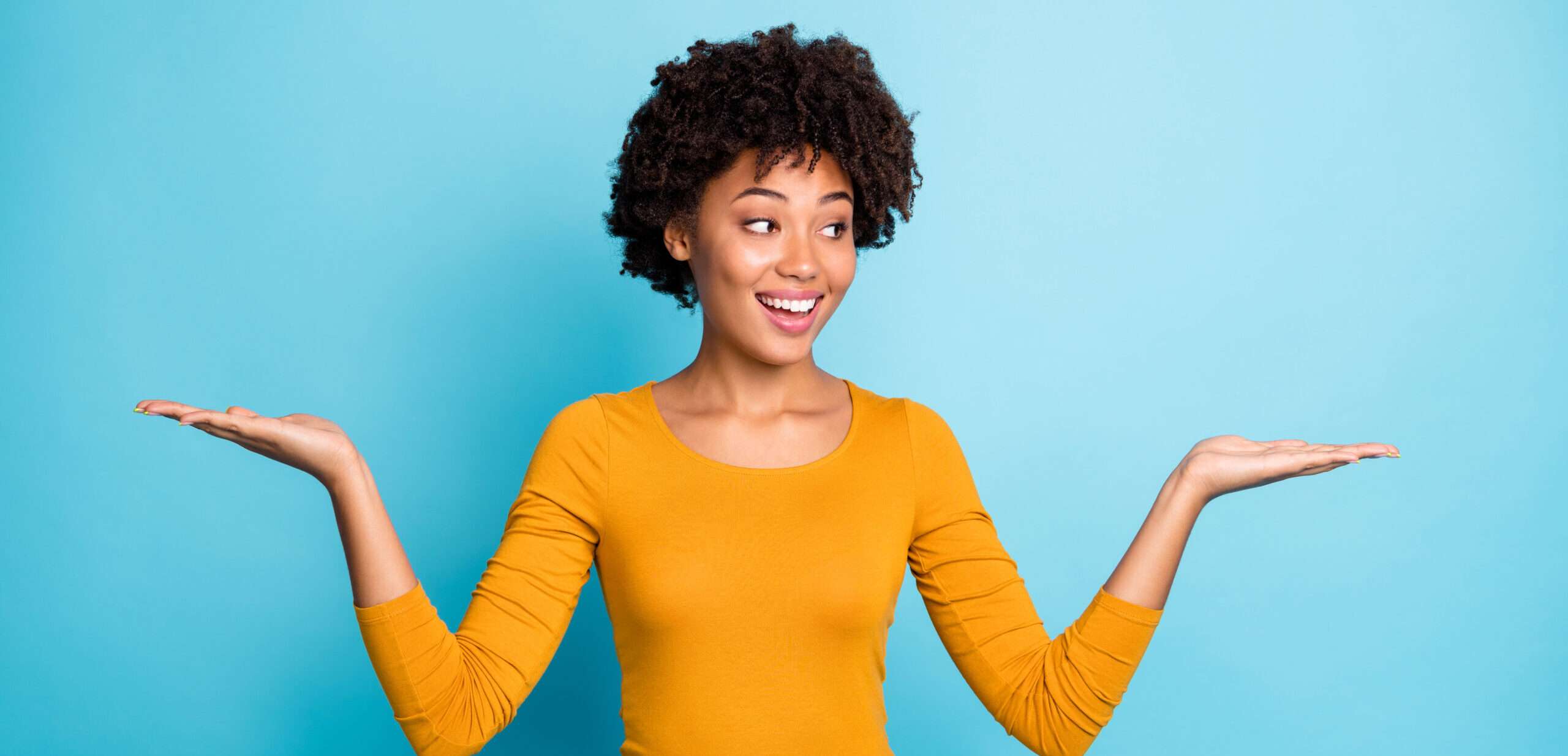 スペインの青い背景に手を広げた若いアフリカ系アメリカ人女性。 スペインの青い背景に手を広げた若いアフリカ系アメリカ人女性。