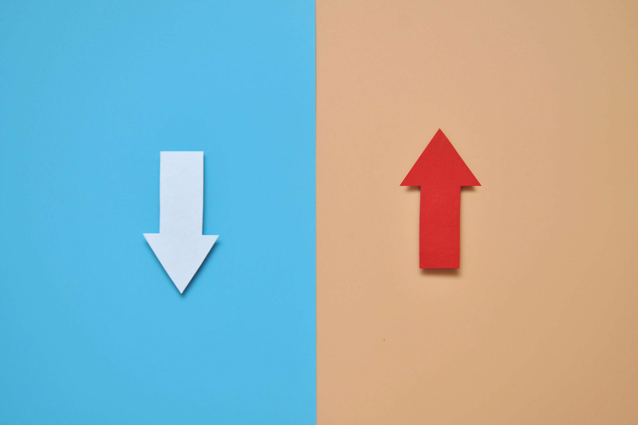 青とオレンジの背景に異なる方向を指す 2 つの矢印。 (「以上」「未満」)